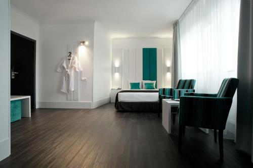 a hotel room with a bed and a table and chairs at Hotel Ecu in Genk