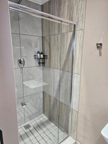 a shower with a glass door and a sink at Cape Town Glam in Welgemoed