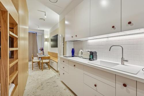 a kitchen with white cabinets and a sink at Lavie Maison - Design Suite & Spa Bath in Paris