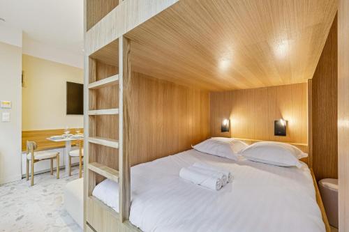 a bedroom with a bed with a wooden headboard at Lavie Maison - Design Suite & Spa Bath in Paris