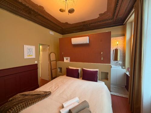 ein Schlafzimmer mit einem großen Bett und lila Kissen in der Unterkunft Kaffee Changé in Gent