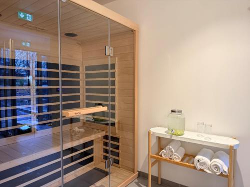 a glass shower in a bathroom with a sink at Greet Hotel Brest Aéroport in Guipavas