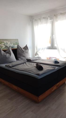 a large bed in a room with two windows at Walldürn Zentrum 2 in Walldürn