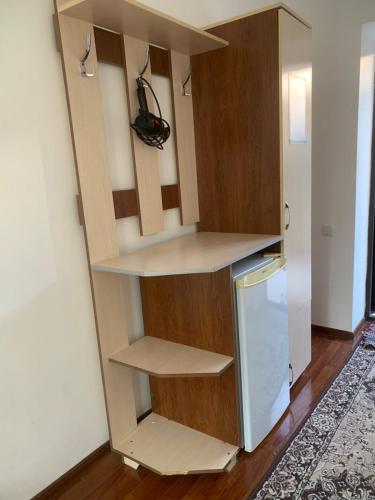 a closet with shelves and a refrigerator in a room at Boomerang Guest house in Cholpon-Ata