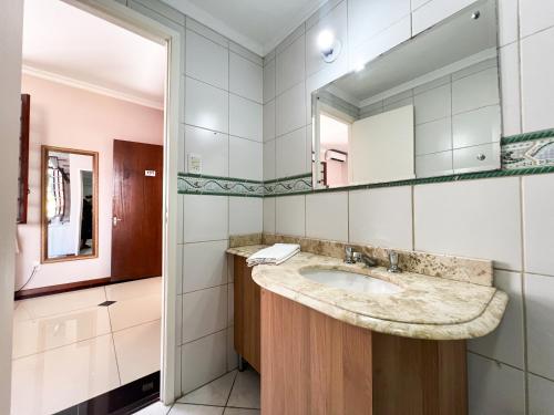 a bathroom with a sink and a mirror at Hotel Villa Souza Ltda in Santa Cruz do Sul