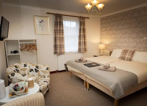 a hotel room with two beds and a chair at The Old Inn in Gairloch