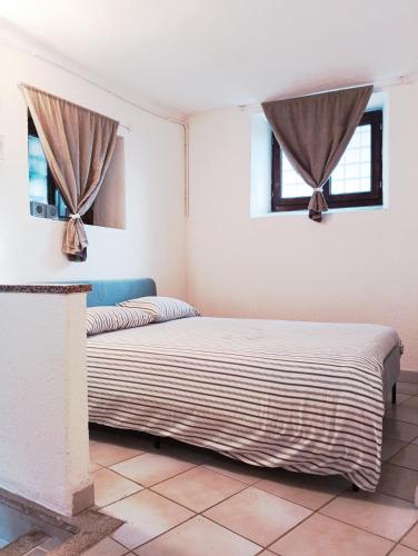 a bedroom with a bed and two windows at Mountain Suite in Raveo