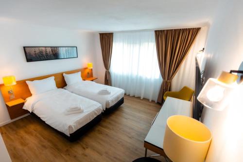 a hotel room with two beds and a desk at CHR Vista in Nicoreşti