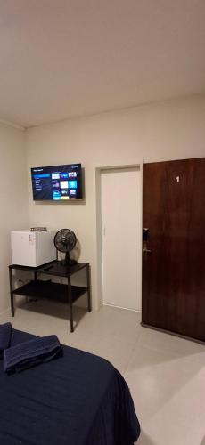a bedroom with a bed and a tv on the wall at Vieira's Residencial in Embu