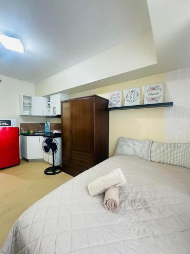 a bedroom with a bed and a red refrigerator at Avida towers davao condo 6thfloor in Davao City