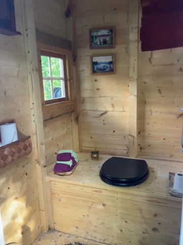 a wooden cabin with a black toilet in it at Gränna Glamping in Gränna