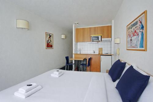 a bedroom with a large white bed with blue pillows at Les Lilas Serviced Apartments in Les Lilas