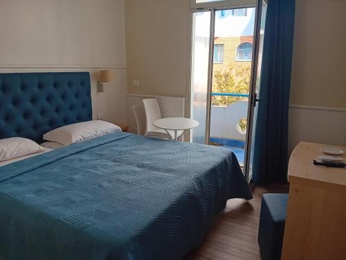 a bedroom with a blue bed and a balcony at Villa Athena in Giardini Naxos