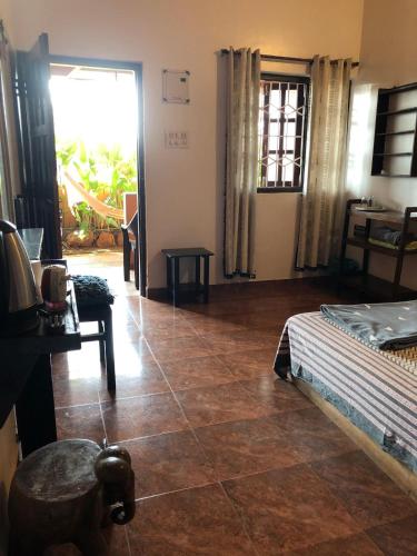 a living room with a bed and a tiled floor at Anjuna Hideout in Anjuna