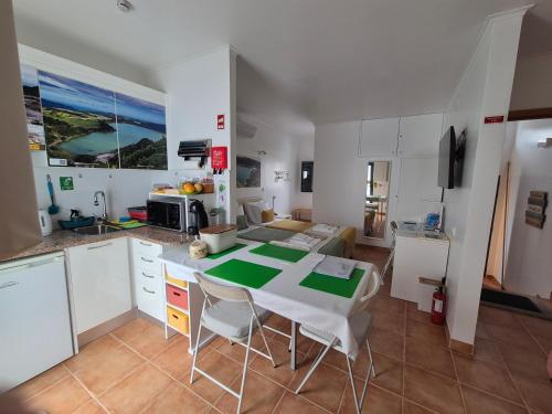 a kitchen with a table and chairs in a room at Caminhos nos Levam pela Ilha in Ponta Delgada