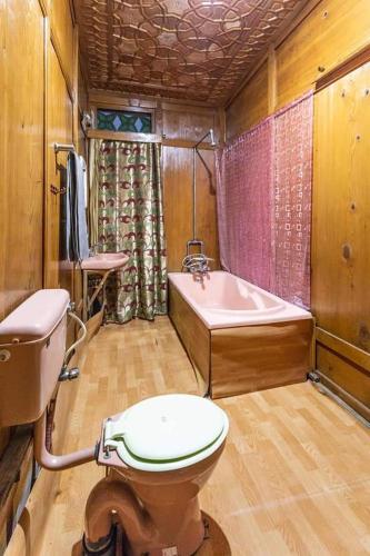 a bathroom with a toilet and a bath tub at White blossom in Srinagar