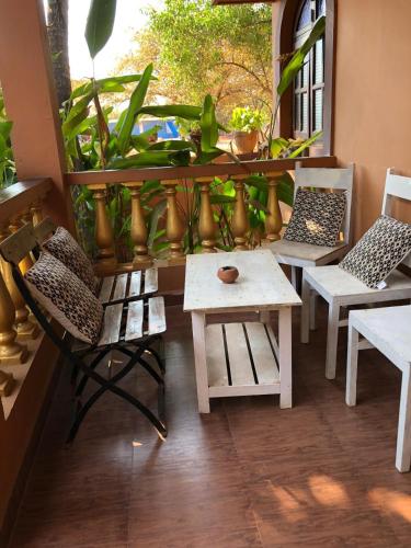 a balcony with chairs and a table and a window at Anjuna Hideout in Anjuna