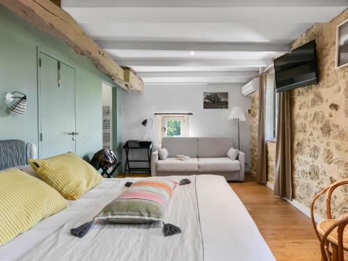 a living room with a bed and a couch at Logis Hôtel La Ferme de Flaran in Maignaut