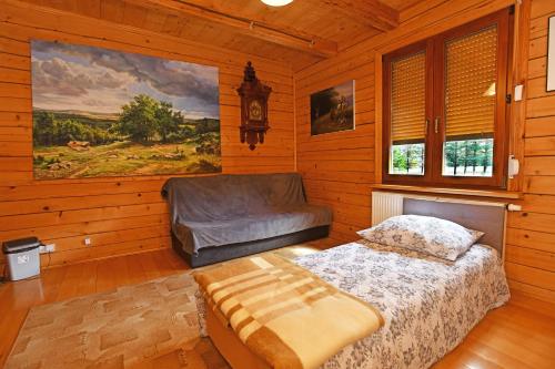 a bedroom with a bed and a chair in it at Apartamenty Pod Gruszką in Tarnawa Górna