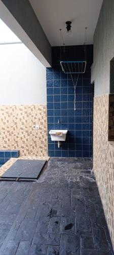 a bathroom with a sink and a blue tiled wall at Casa para agrishow in Ribeirão Preto
