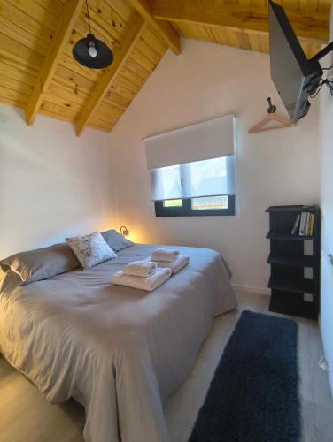 a bedroom with a large bed with a window at Patagonia Tiny house 3 in El Chalten