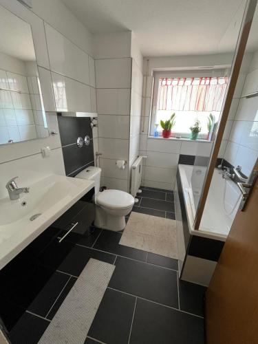 a bathroom with a toilet and a sink and a tub at FeWo Edelweiß Jäger in Nesselwang