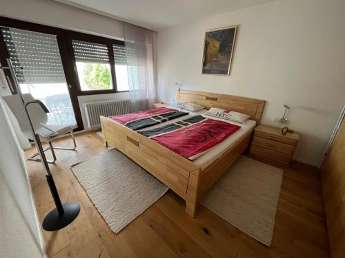 a bedroom with a wooden bed with a red blanket at FeWo Edelweiß Jäger in Nesselwang