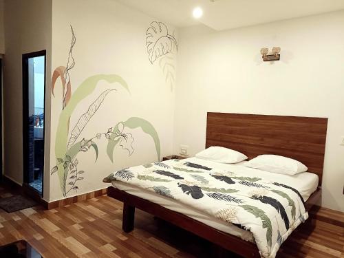 a bedroom with a bed with flowers painted on the wall at Tunga Vilasa in Tīrthahalli