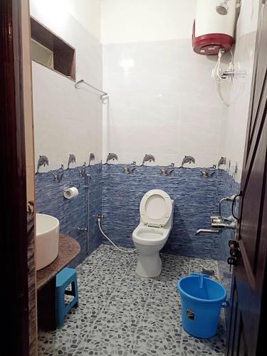 a bathroom with a toilet and a blue wall at Tunga Vilasa in Tīrthahalli
