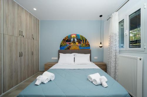 a bedroom with a bed with towels on it at Porto Blue Heaven in Porto Rafti