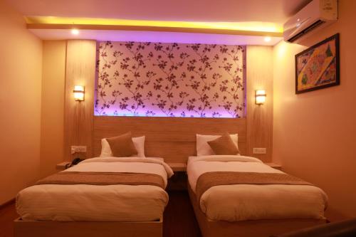 two beds in a hotel room with a window at Komal Hotel in Lālbhitti