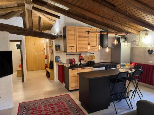 a kitchen with wooden cabinets and a black counter top at Mansarda al Noce in Pellizzano