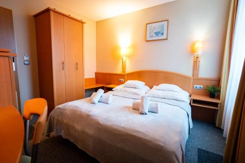 a hotel room with a large bed with two pillows at Marben Panzió in Hegykő