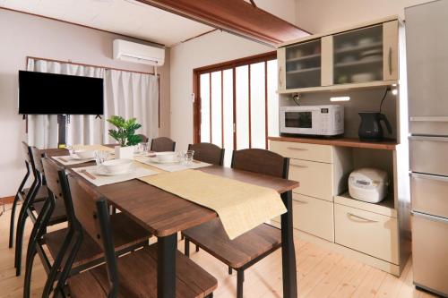 a kitchen with a dining room table with chairs at 南栄駅1分 3寝室 最大9名 キッチン付一棟貸し パーキング1分 Showa Retro Japanese House 1min Station Entire Home for 9 in Toyohashi