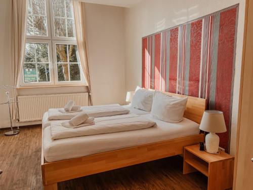 a bedroom with a large bed with white sheets and pillows at "Unnen" in der Alten Schule Greetsiel in Krummhörn