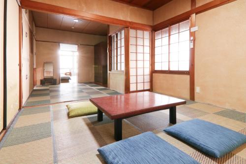 a room with a table and two ottomans at 南栄駅1分 3寝室 最大9名 キッチン付一棟貸し パーキング1分 Showa Retro Japanese House 1min Station Entire Home for 9 in Toyohashi