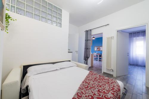 a bedroom with a white bed and a red rug at Di Giuseppe Laura in Ladispoli