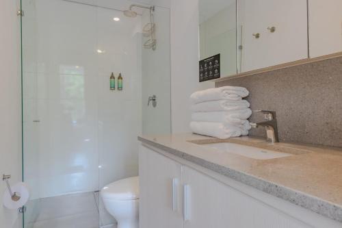 a bathroom with a sink and a shower with towels at Luxury Studio El Poblado Pool Rooftop 4th Floor in Medellín