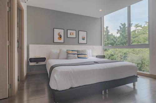 a bedroom with a large bed and a large window at Luxury Studio El Poblado Pool Rooftop 4th Floor in Medellín