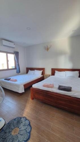 a bedroom with two beds and a rug at Dan Family Homestay in Ấp Bình Hưng