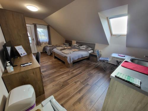 a room with a bed and a desk with a television at Li-Vi Apartman Debrecen in Debrecen