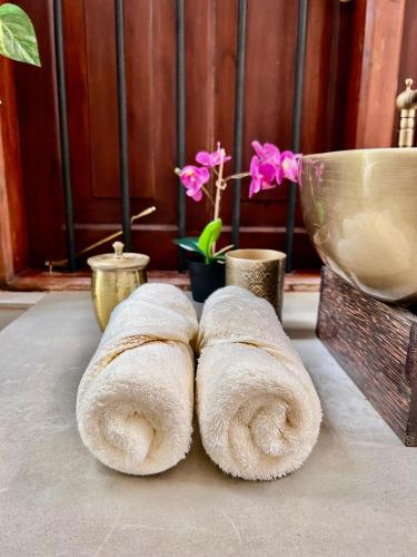 a group of towels sitting on a table with flowers at Colonial Boutique Villa Kandy in Kandy