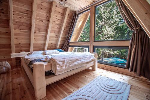 a bedroom with a bed in a room with windows at Green Hideaway SPA in Žabljak
