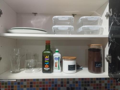 a bottle of wine and other kitchen items in a refrigerator at UniversiFlat in Ponta Grossa