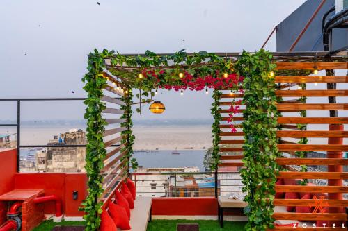 a pergola covered in ivy and flowers on a balcony at Zostel Varanasi in Varanasi
