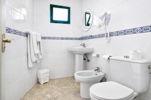a white bathroom with a toilet and a sink at Las Faluas by Youroom in Playa del Ingles
