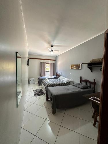 a hotel room with two beds and a bathroom at Prime Garden Pousada in Socorro