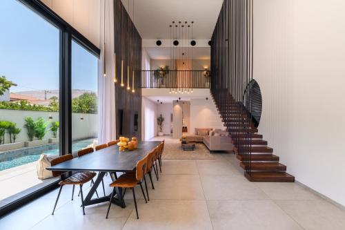a dining room with a table and some chairs at אחוזת דוד - וילה יוקרתית עם בריכה פרטית מחוממת ומקורה in Hatzor haglilit