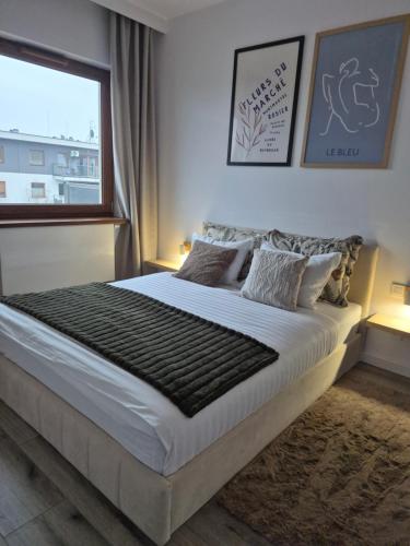 a bedroom with a large bed with a window at Apartament REN in Częstochowa