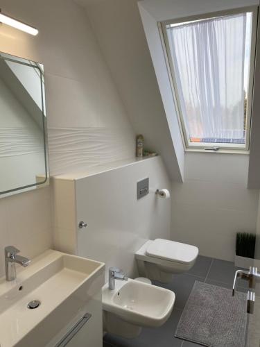 a white bathroom with a sink and a toilet at Ady13 Vendégház Eger in Eger